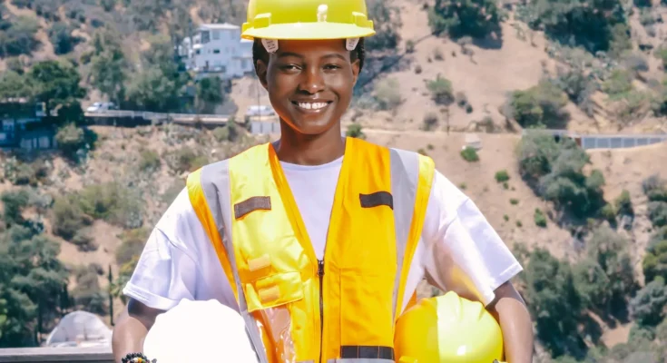 woman engineer holding yellow hardhats