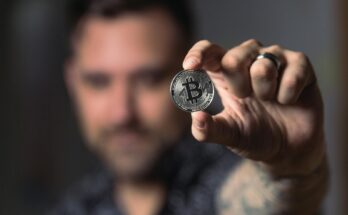 person holding silver bitcoin coin